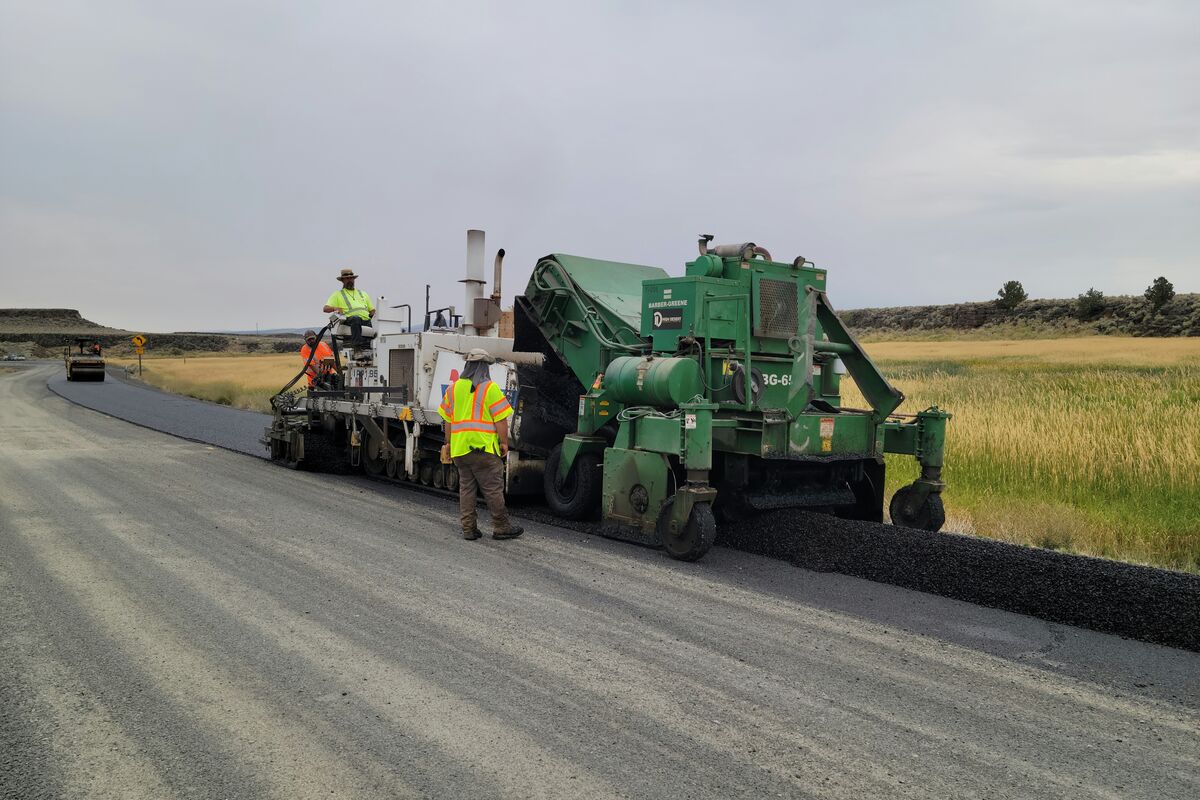 Asphalt paving crew laying road surface
