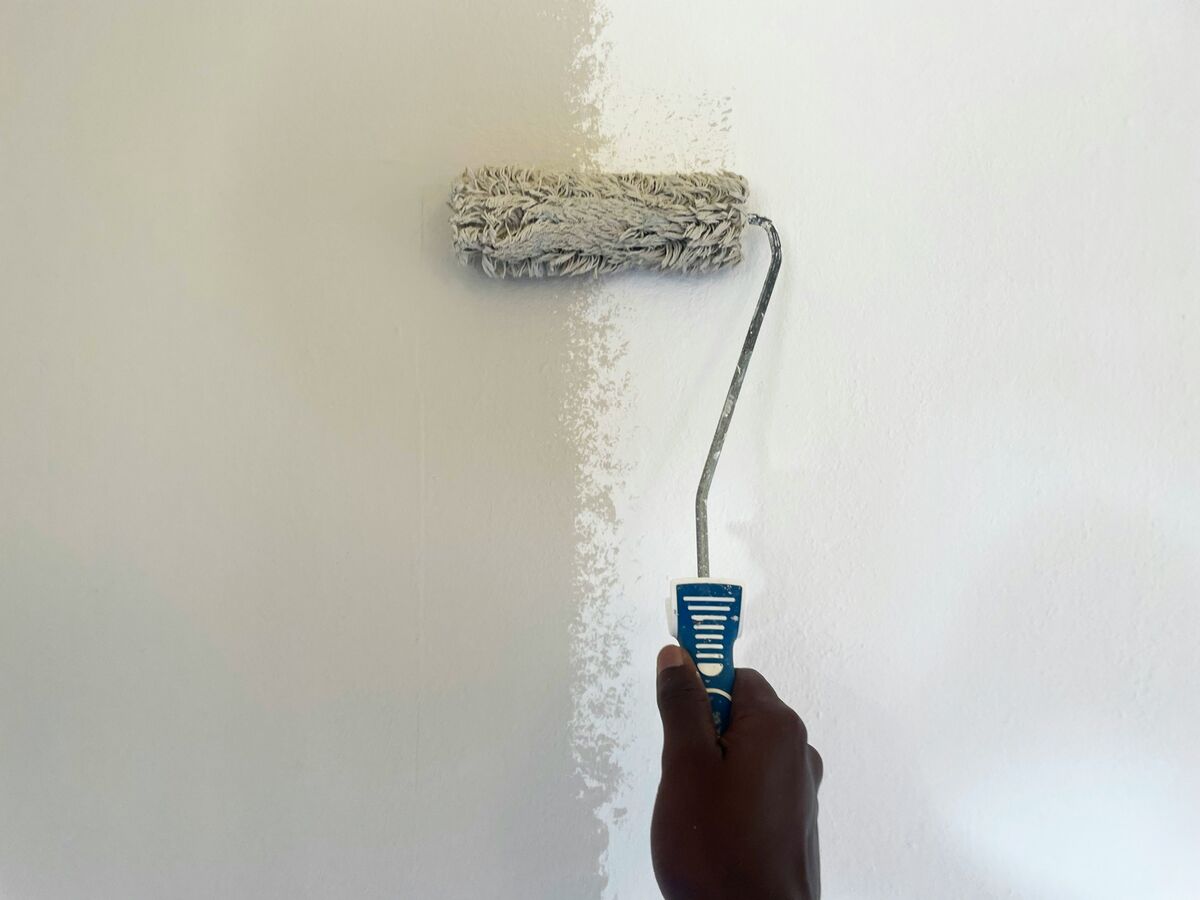Paint roller applying paint to wall